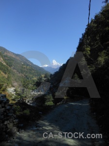 Annapurna sanctuary trek road tree snow himalayan.