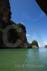 Limestone cliff water tree southeast asia.