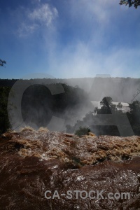 South america waterfall spray iguazu river tree.